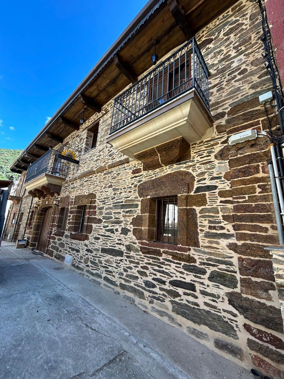 Fachada de piedra con balcones de forja de Casa Fede